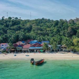 a boat sitting in the water on a beach at Elephant Guesthouse in Koh Rong Island