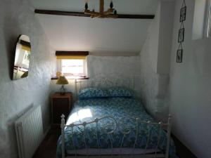 a bedroom with a bed and a ceiling fan at Converted rural stone cottage, Swansea in Swansea