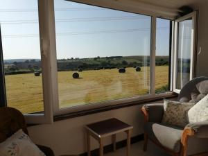 a living room with a large window looking out at a field at Converted rural stone cottage, Swansea in Swansea