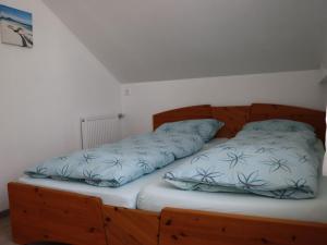 a bed with two pillows on top of it at Ferienwohnung Ernatsreute in Überlingen