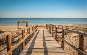 a wooden boardwalk to the beach with the ocean at 3 Bedroom Cozy Apartment In Santa Pola in Santa Pola +12 photos