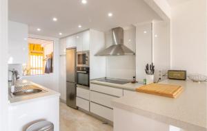 a white kitchen with a sink and a stove at 3 Bedroom Cozy Apartment In Santa Pola in Santa Pola