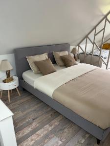 a bedroom with a large bed with a wooden floor at La petite maison de Kerguiniou in Glomel