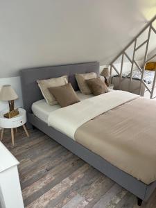 sypialnia z dużym łóżkiem i drewnianą podłogą w obiekcie La petite maison de Kerguiniou w mieście Glomel