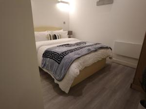 a bedroom with a bed with a wooden floor at Stylish 2 bedrooms, 2 bathrooms with workspace in Milton Keynes in Milton Keynes