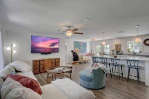 a living room with a person sitting on a couch at Turtle Island - Family Friendly Pool Home -Welcome in Naples