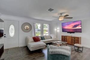 a living room with a couch and a ceiling fan at Turtle Island - Family Friendly Pool Home -Welcome in Naples