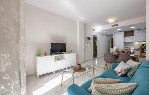 ein Wohnzimmer mit einem blauen Sofa und einer Küche in der Unterkunft Nice Apartment In Fuengirola With Outdoor Swimming Pool in Fuengirola
