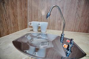 a sink with a faucet and two cups on a counter at 龍江大飯店 in Shuili