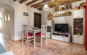 comedor con mesa, sillas y TV en Awesome Home In Alfarnate With Kitchen, en Alfarnatejo