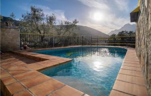 a swimming pool with a fence and mountains in the background at Awesome Home In Alfarnate With Kitchen in Alfarnatejo