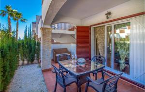 a patio with a glass table and chairs on a balcony at Cozy Apartment In Torrevieja With Wifi in Torrevieja