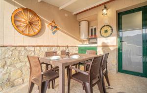 una mesa y sillas en una cocina con reloj en la pared en Awesome Home In Alfarnate With Kitchen, en Alfarnatejo