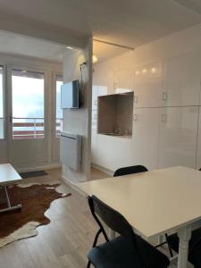 een keuken met een tafel en stoelen in een kamer bij Appartement 2 ch 40 m2 au pied des pistes de ski in Enchastrayes