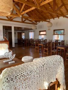 Hosteria Hainen في إل كالافاتي: غرفة كبيرة بها سرير وطاولات وكراسي