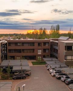 un edificio de apartamentos con coches aparcados en un aparcamiento en Bosques de Dharma en Maipú