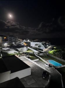 a view of a city at night with the moon at OCEAN GARDENS 5 in Margate