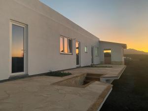 a white house with a bench in front of it at Villa Verano Apartamentos Compartidos Villaverde in La Oliva