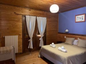 1 dormitorio con 2 camas y pared azul en Hosteria Hainen en El Calafate