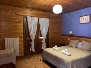 a bedroom with two beds and a blue wall at Hosteria Hainen in El Calafate