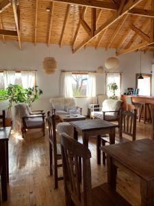 Hosteria Hainen في إل كالافاتي: غرفة معيشة مع طاولات وكراسي خشبية