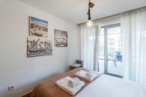 um quarto com uma cama com duas toalhas em D João IV Apartment With Terrace by LovelyStay no Porto