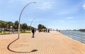 a street light on a sidewalk next to the water at 3 Bedroom Cozy Apartment In Huelva in Huelva
