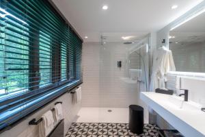Hostellerie La Cheneaudière & Spa في كولروي لا روش: حمام مع حوض ومرآة