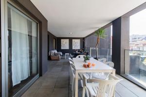 um quarto com uma mesa branca e cadeiras numa varanda em D João IV Apartment With Terrace by LovelyStay no Porto