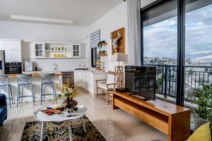 הבית על ההר - Ella Sun في إيلات: مطبخ وغرفة معيشة مع نافذة كبيرة