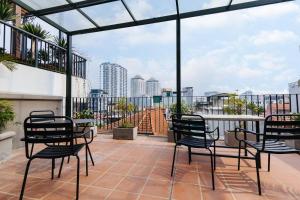 un patio con sedie e un tavolo sul balcone. di LUCK APART 9 - Hanoi WestLake Balcony Apartment a Hanoi