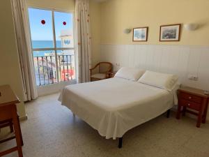 Hotel Cabello في توريمولينوس: غرفة نوم مع سرير وإطلالة على المحيط