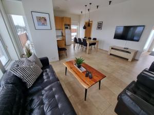 a living room with a leather couch and a table at Saeluhus Apartments & Houses in Akureyri
