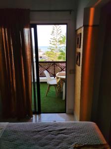 a bedroom with a door open to a patio with a table at Golf del Sur Albatros Park Piscina Climatizada fast wifi in San Miguel de Abona