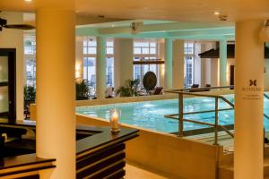 a large swimming pool in a hotel lobby with a pool at Sunday Schwielowsee Resort - Apartment in Werder
