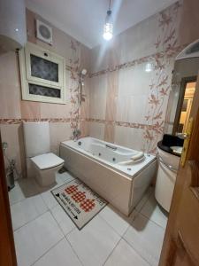 a bathroom with a tub and a toilet and a sink at البحر الأعظم in Cairo