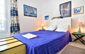 エーグ・モルトにある2 Bedroom Amazing Home In Aigues-Mortesの青い毛布が掛けられたベッドのある寝室
