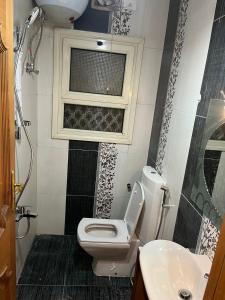 a bathroom with a toilet and a window and a sink at البحر الأعظم in Cairo