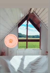 um quarto com uma cama e uma grande janela em Chalé Sol com hidromassagem em meio a natureza em Piçarras
