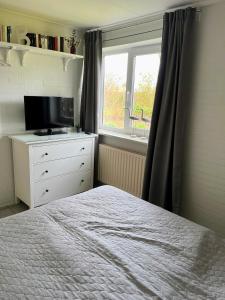 a bedroom with a bed and a television and a window at Wunderschönes Ferienhaus in Strandnähe in Retranchement