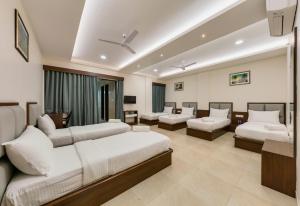 KudālにあるHotel Aaradhya Adorerのベッド2台とソファが備わるホテルルームです。