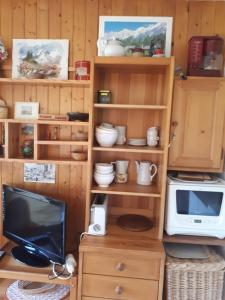 a toy kitchen with a microwave and a television at Studio belle vue sur les montagnes in Le Grand-Bornand