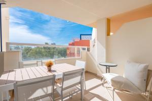 een eetkamer met een tafel en stoelen en een groot raam bij Apartamento de diseño 2 terrazas en Estepona by Rent Me in Estepona