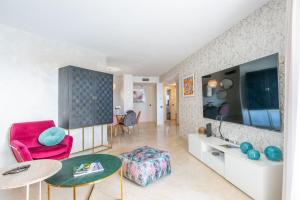 een woonkamer met een rode stoel en een tafel bij Apartamento de diseño 2 terrazas en Estepona by Rent Me in Estepona