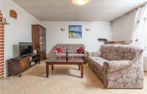 een woonkamer met een bank en een tv bij Cozy Home In Cokuni With Kitchen in Mutvoran