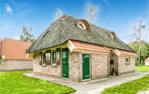 una antigua casa de ladrillo con techo de paja en Gorgeous Home In Ijhorst With Wifi en IJhorst