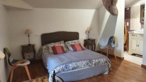 - une chambre avec un lit et deux chaises dans l'établissement L'OUSTAL D'ADELE proche Canal du Midi et Moissac, à Saint-Nicolas-de-la-Grave
