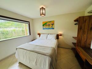 1 dormitorio con 1 cama blanca y ventana en Apartamento na Vila La Torre en Porto Seguro