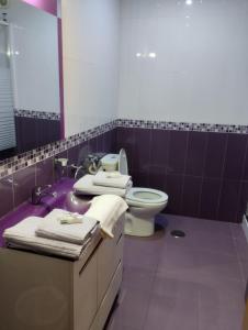 サンティアゴ・デ・コンポステーラにあるAiriños Airesの紫色のバスルーム(トイレ、シンク付)