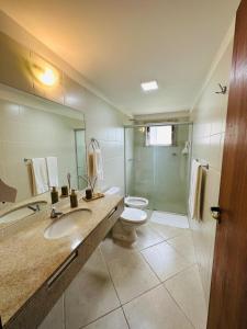 y baño con lavabo, aseo y ducha. en Apartamento na Vila La Torre en Porto Seguro